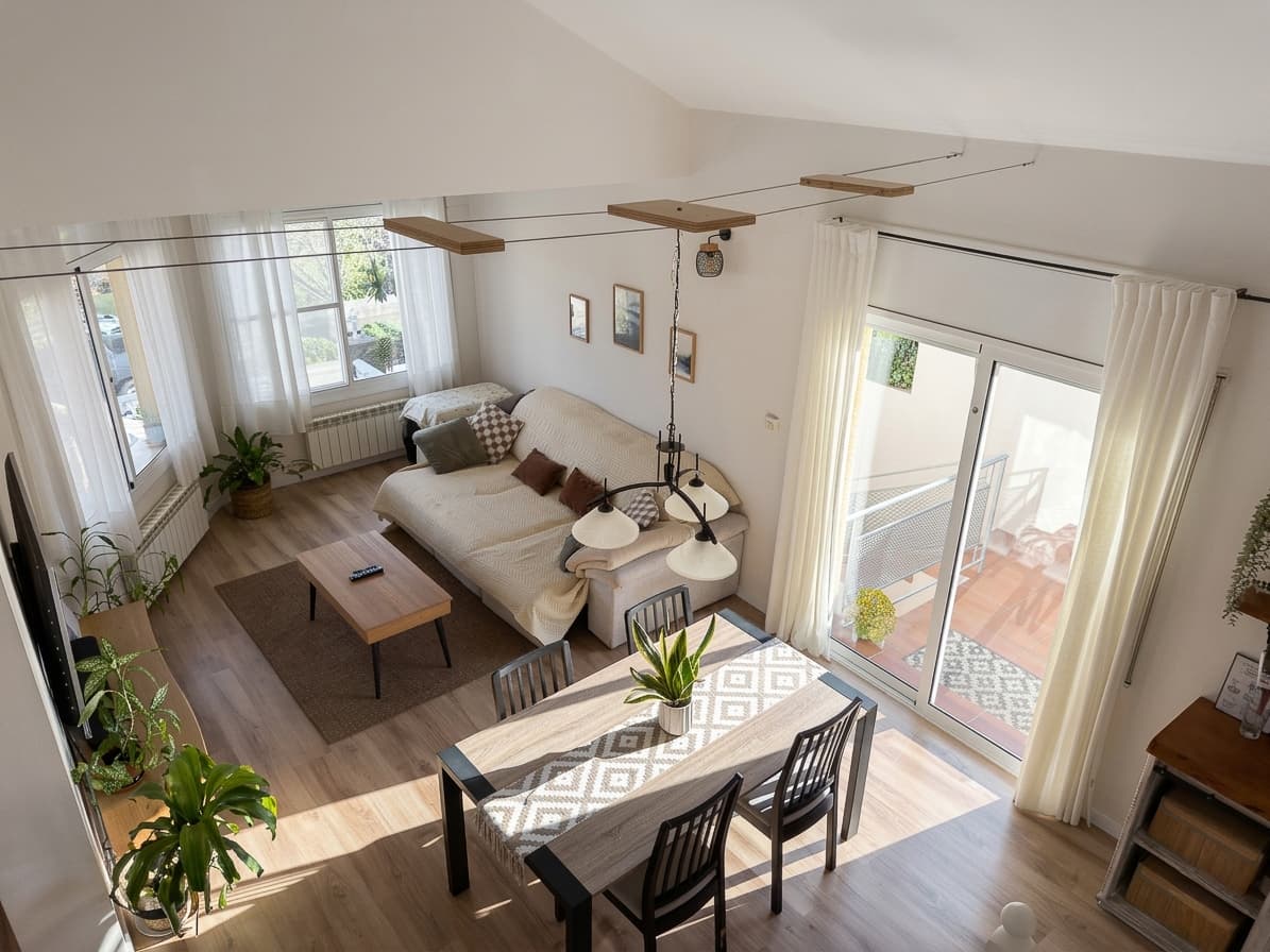Salón visto desde lo alto, con el sofá y la mesa del comedor